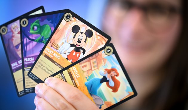Sammelkarten Locarna mit Disneyfiguren in einer Hand