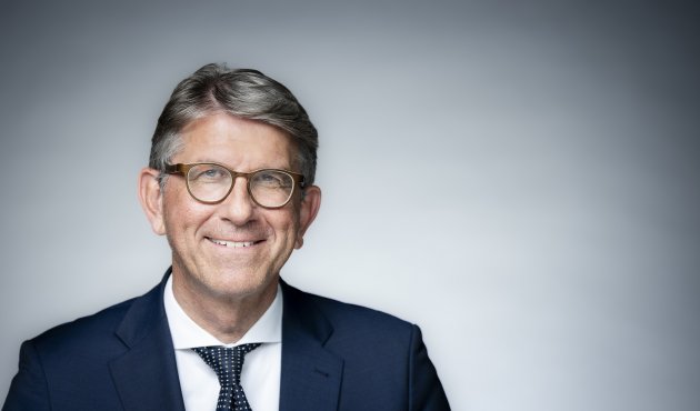 Kulturstaatsminister Wolfram Weimer lächelnd vor heller Wand