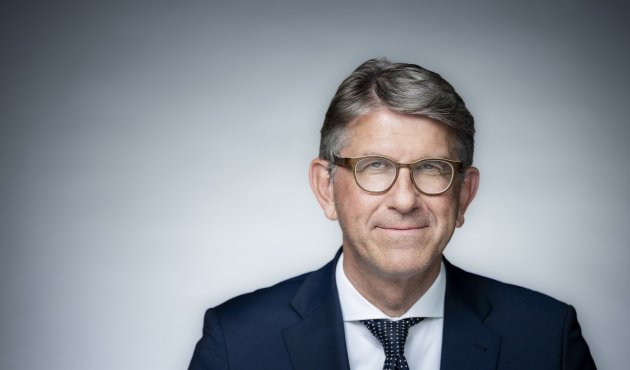 Kulturstaatsminister Wolfram Weimer lächelnd vor heller Wand