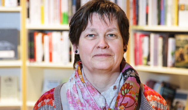 Ein Foto von Sabine Hunzinger vor einem Bücherregal