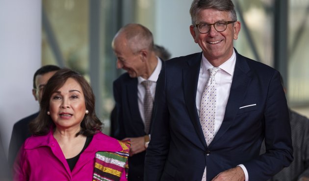 Ein Foto von der Eröffnungsveranstaltung der 77. Frankfurter Buchmesse. Die philippinische Senatorin Loren Legarda trägt eine pinke Jacke und einen bunten Schal. Neben ihr steht Wolfram Weimer, Staatsminister für Kultur und Medien, in einem dunklen Anzug mit einer hellen Krawatte. Im Hintergrund sind weitere Personen zu sehen.