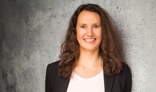 Porträt Susanne Barwick vor einer grauen Wand