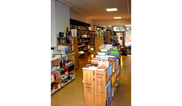 Ein Blick in den Buchladen Erlkönig: Vorne zwei Regale, links "Bestseller & Evergreens", rechts "Schwule Jungs". Links an der Wand Regale
