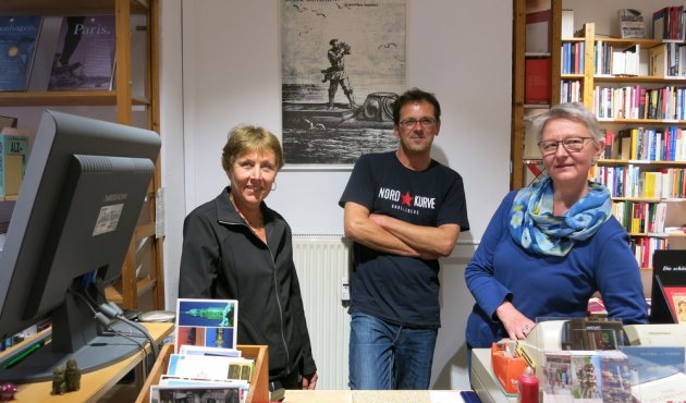 Drei Buchhändler am Tresen der Buchhandlung