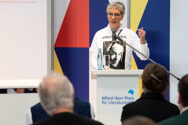 Börsenvereinsvorsteherin Katrin Schmidt-Friderichs trägt bei ihrem Grußwort ein T-Shirt mit einem Porträt des algerischen Schriftstellers Boualem Sansal