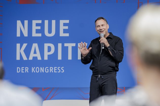 Sebastian Fitzek gestikuliert lächelnd auf der Bühne