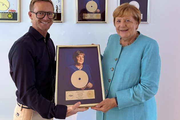 Argon-Geschäftsführer Frederik Wehmeier (l.) und Angela Merkel zeigen die Goldene Schallplatte