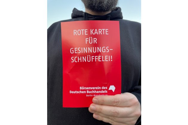 Eine Demonstrant zeigt die "Rote Karte für Gesinnungsschnüffelei"