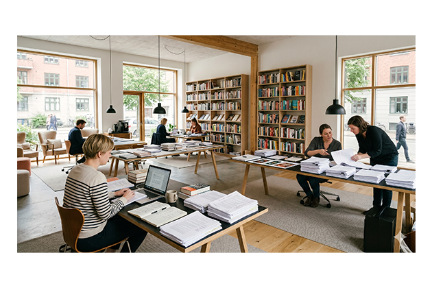 Foto von Mitarbeitenden eines Verlags an ihren Schreibtischen.