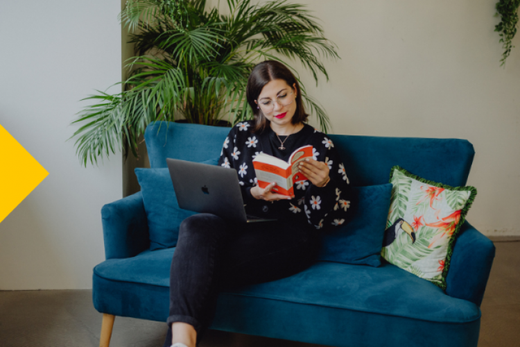 Evelyn Unterfrauner mit einem Buch auf ihrem Sofa