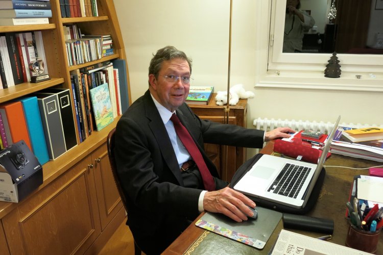 Alain Gründ im Anzug in seinem Büro