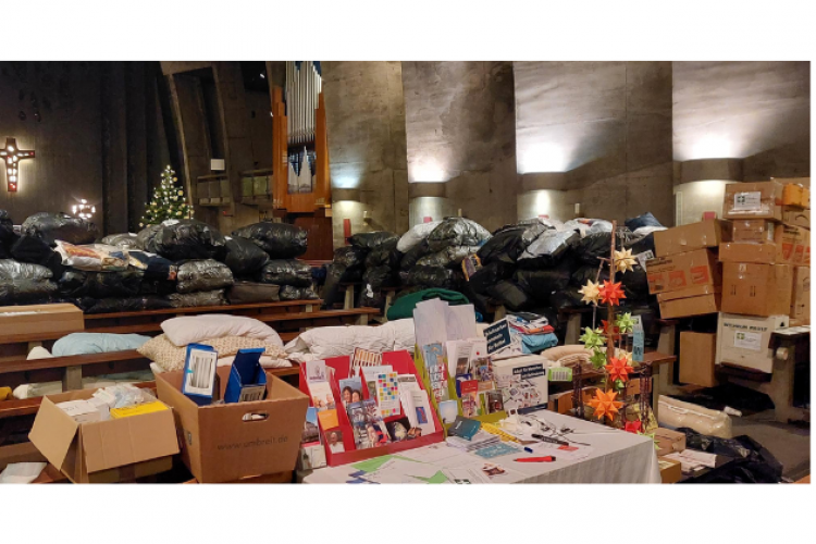 Praktische Hilfe: Pakete mit Decken und Erste-Hilfe-Kästen und weiteren Gütern für die Ukraine in einer Kirche