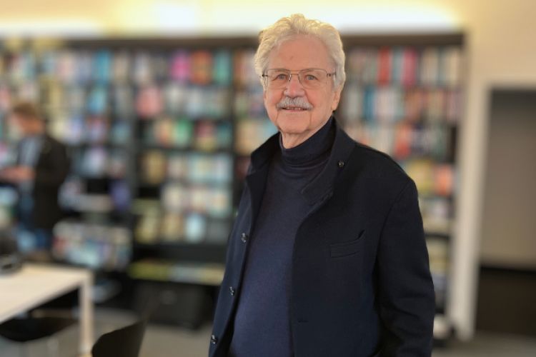 Paul Maar im stehend vor einem Bücherregal im S.Fscher Verlag