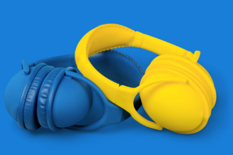 Ein paar blauer und gelber Kopfhörer vor blauem Hintergrund