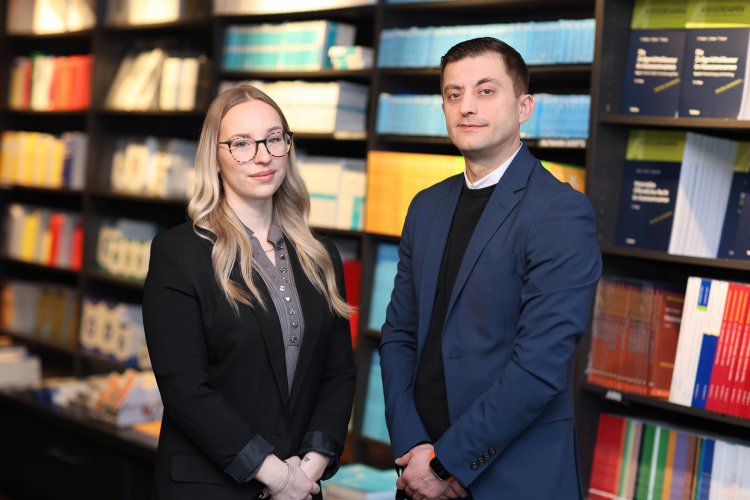 Leonie Geske und Sergiy Esposito stehen im Kulturkaufhaus Dussmann vor einer Bücherwand