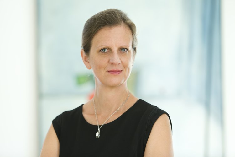 Porträtfoto von Stefanie Hölscher vor unscharfem Bürohintergrund  