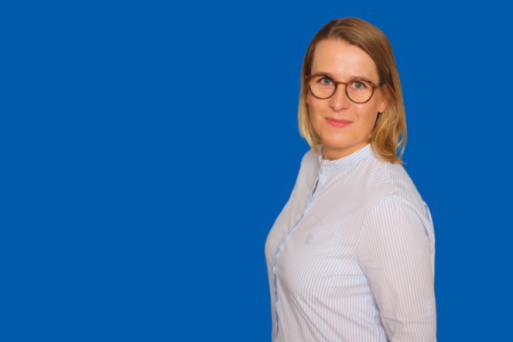 Sabrina Kreuz vor blauem Hintergrund 