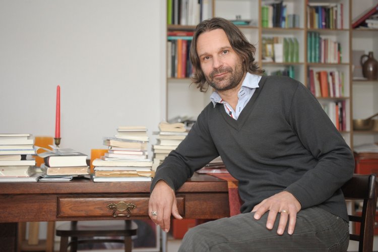 Schriftsteller Moritz Rinke sitz in seiner Wohnung am Schreibtisch 