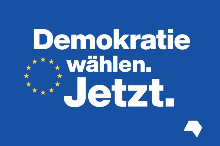 Schriftzug "Demokratie wählen. Jetzt" auf blauem Hintergrund mit Europa-Sternen