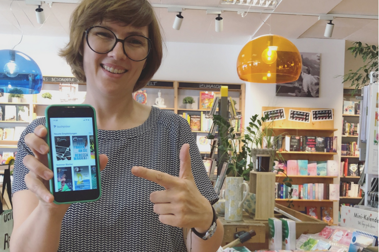 Lena Grimm hält in ihrem Laden das Handy mit der Buchpicker-App in die Kamera
