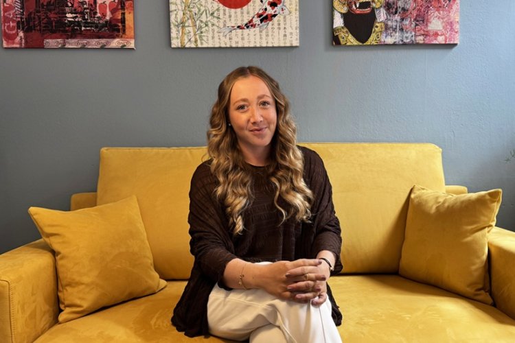 Foto von Leonie Strunk, auf einem gelben Sofa sitzend