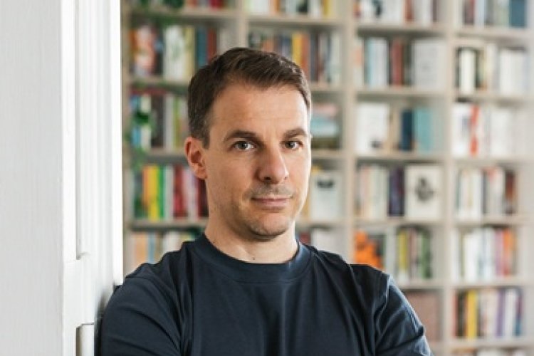 Foto von Thomas Hummitzsch, vor einem Bücherregal