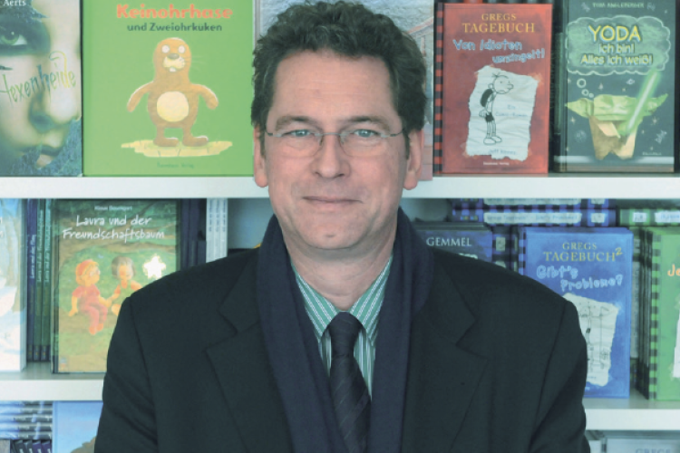 Bodo Horn-Rumold vor Bücherregal