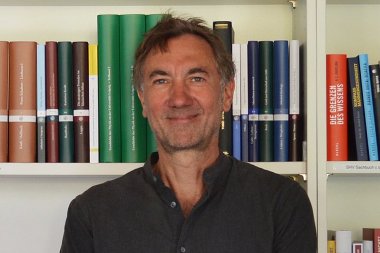 Rüdiger Müller vor Buchregal stehend