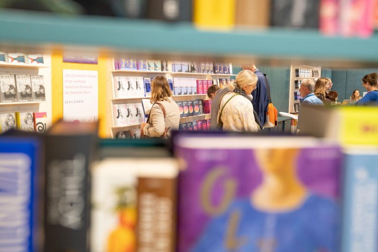 Kund:innen stöbern in Buchregalen