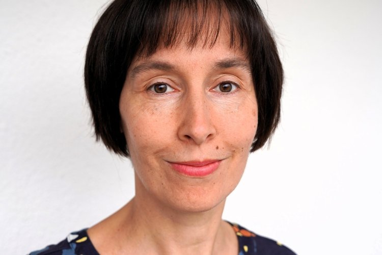 Porträt Sarah Haag in blauer Bluse mit Blumenmuster