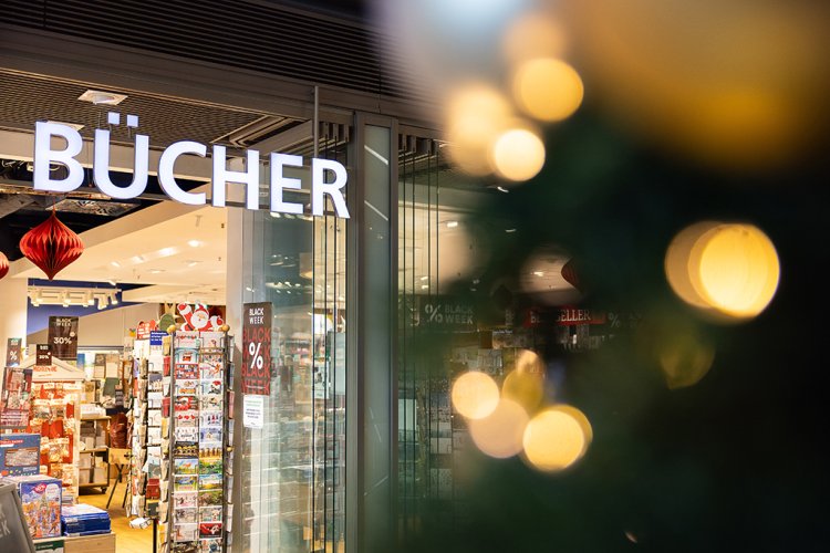 Eingang einer Buchhandlung mit der Beschriftung "Bücher", daneben ein Weihnachtsbaum