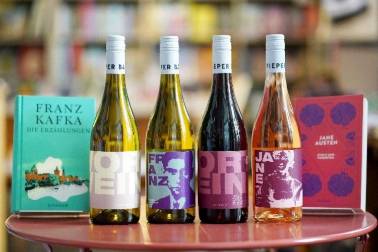 Vier Flaschen Wein vor Bücherregal