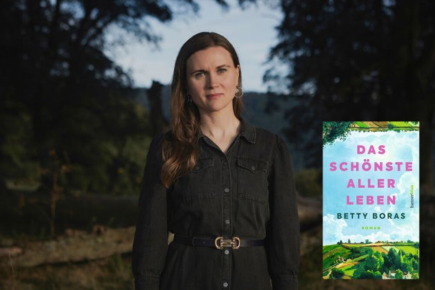 Betty Boras in einem Park unter Bäumen mit ihrem Buchcover