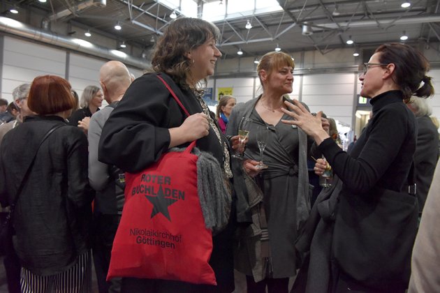 Drei Leute sprechen, eine trägt eine Tasche vom Buchladen Rote Straße Göttingen
