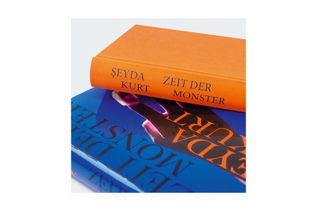 Foto von zwei aufeinander gestapelten Büchern des Titels: Zeit der Monster, eins mit und eins ohne Schutzumschlag.