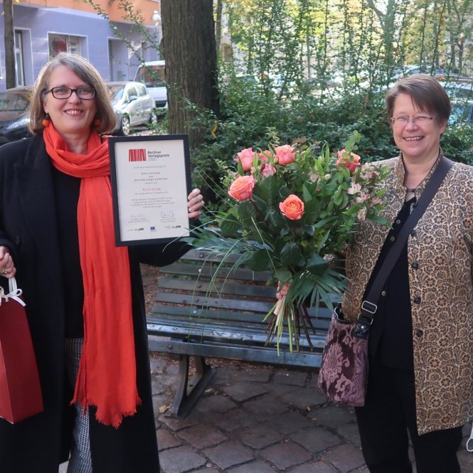 Strahlen: AvivA-Verlegerin Britta Jürgs mit Urkunde und Johanna Hahn mit großem Blumenstrauß