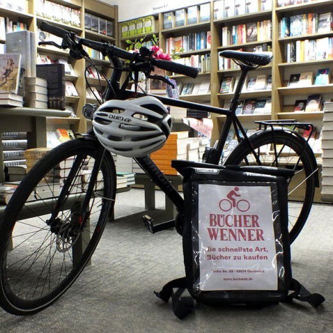 Bild aus der Buchhandlung Wenner: Fahrrad mit Werbeschild für Lieferservice