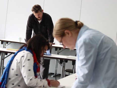 Drei Jurymitglieder beugen sich über Bücher