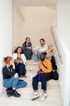 Junge Gäste, die auf einer Treppe sitzen