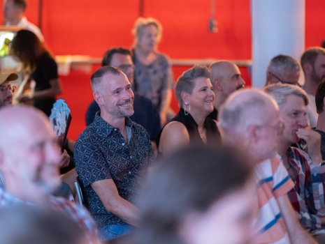 Menschen im Publikum lächeln. 