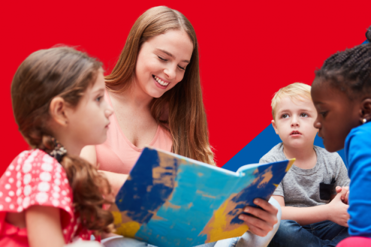 Vorlesesituation: Drei Kinder mit unterschiedlicher Hautfarbe hören einer jungen Frau beim Vorlesen zu