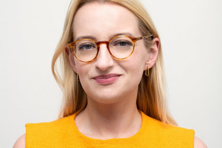 Porträtfoto von Leonie Seibold in gelbem Kleid und mit Brille