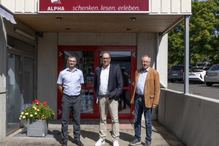 Thomas Sczigiol, Tim Schneider, Klaus Meiß vor einer Alpha Buchhandlung