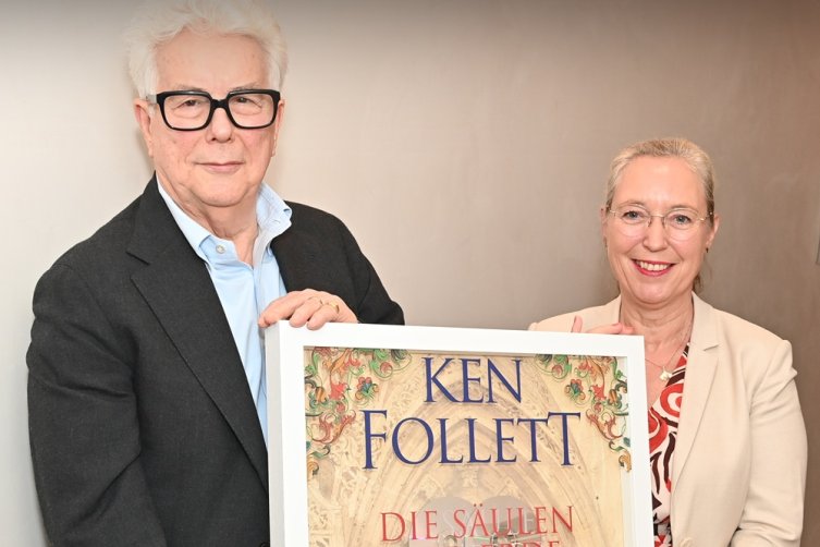 Ken Follett und Kerstin Kaiser halten gemeinsam einen Bilderrahmen mit goldener Schallplatte hoch